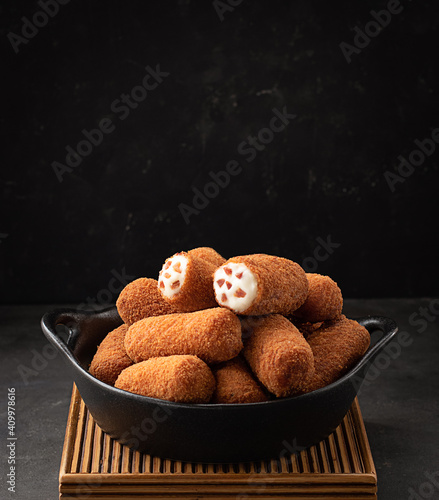 Croquettes served in a bowl on dark background photo
