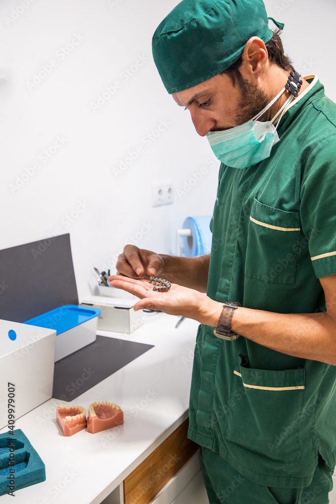 Side view of dentist holding gray dental plaster cast in dentistry