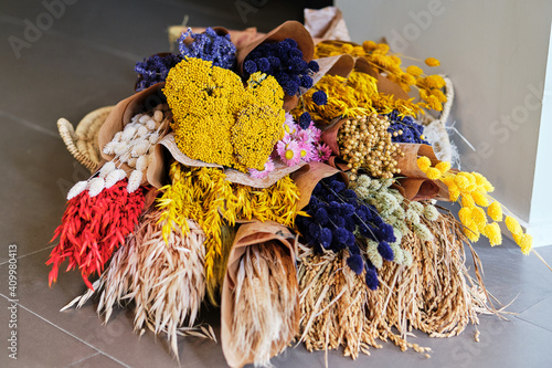 Colorful assorted fresh and dried flowers arranged in bouquets wrapped in craft paper in flower shop photo