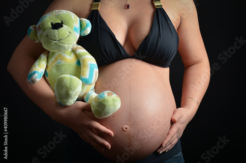 Pregnant belly with plush monkey toy  photo