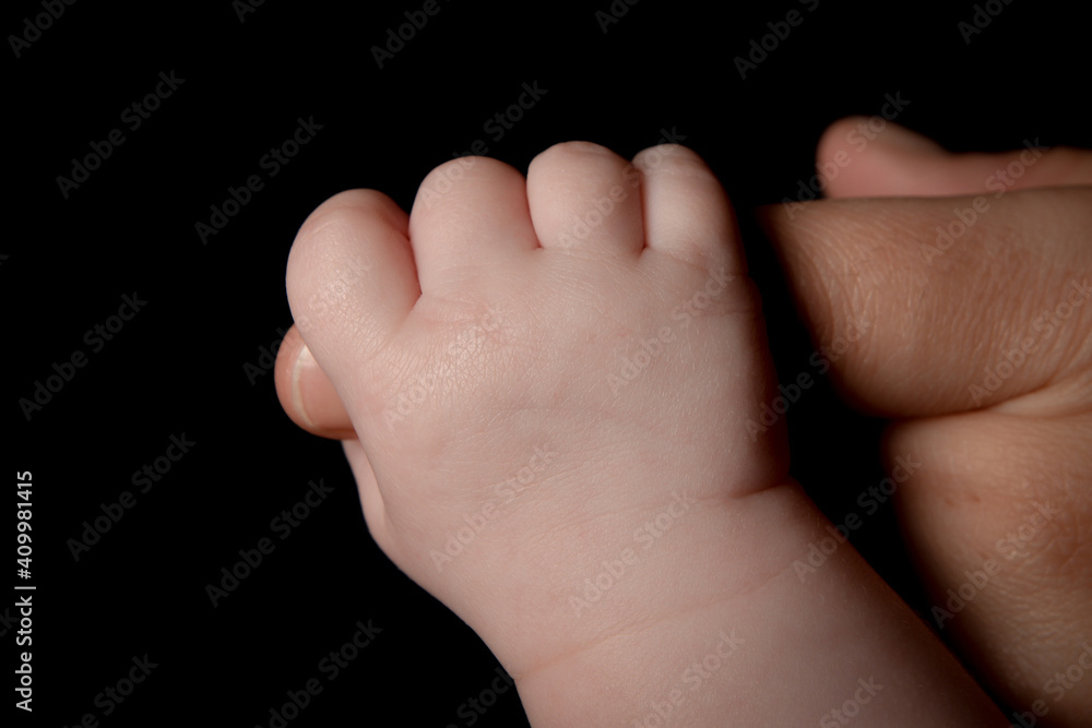 Baby hand holding parent finger Baby hand holding parent finger