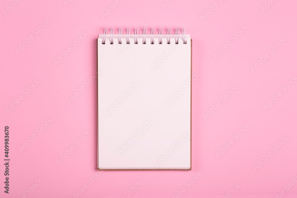 Blank notepad or notebook on a pink background. Space for inscriptions and notes Blank notepad or notebook on a pink background. Space for inscriptions and notes