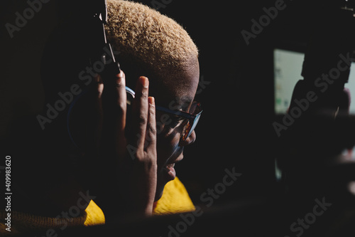 Side view of african American female radio host working in dark broadcast studio and speaking in microphone photo