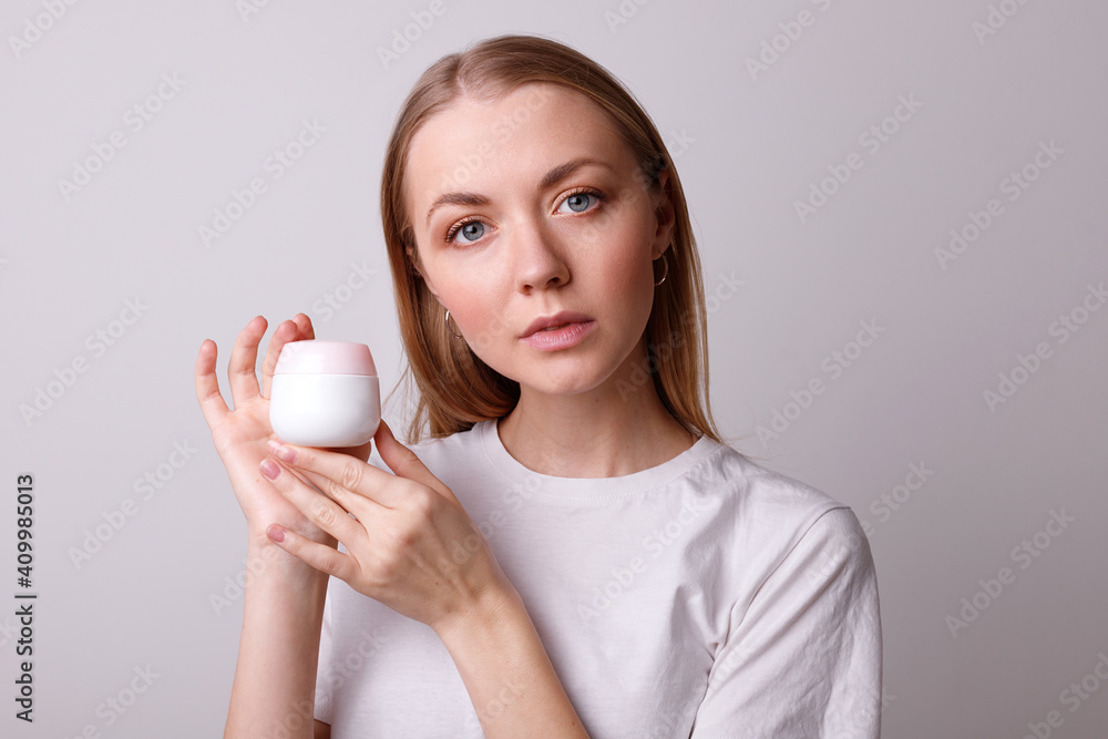 Young girl holds cream on white background Young girl holds cream on white background