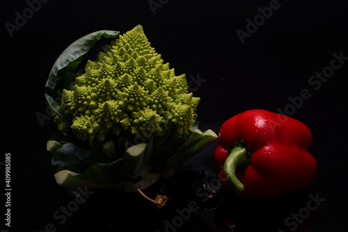 vegetables on black background romanesco broccoli and bell pepper