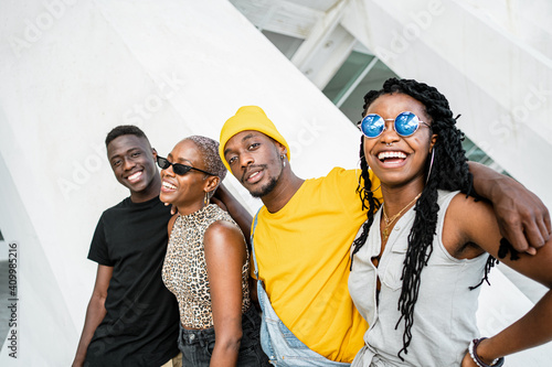 Group of cheerful African American stylish people standing together on the street looking at camera