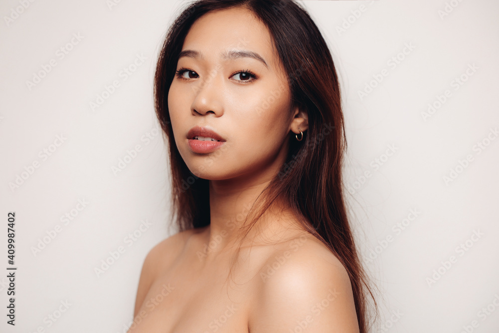 Portrait of naked young Chinese woman looking at camera over white background Portrait of naked young Chinese woman looking at camera over white background