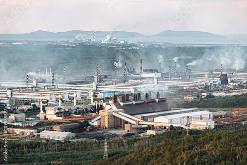 Aerial view of the factory. Environmental pollution. The pipes emit smoke into the atmosphere.