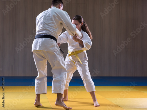 Young judo girl practicing kumikata with adult opponent