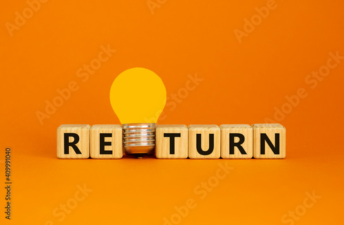 Return symbol. Wooden cubes with word 'return'. Yellow light bulb. Beautiful orange background. Business and return concept. Copy space. photo