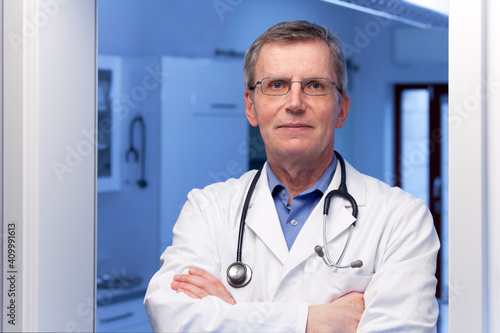 Mature confident doctor standing in front of surgery room