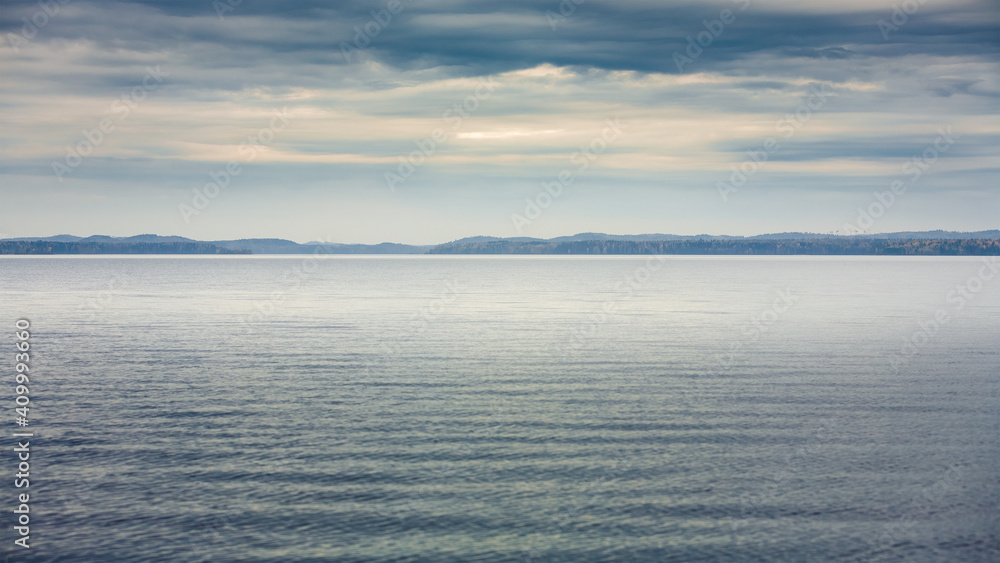 Karelian lake and island with dramatic sky. Northern nature of Russia. Republic of Karelia