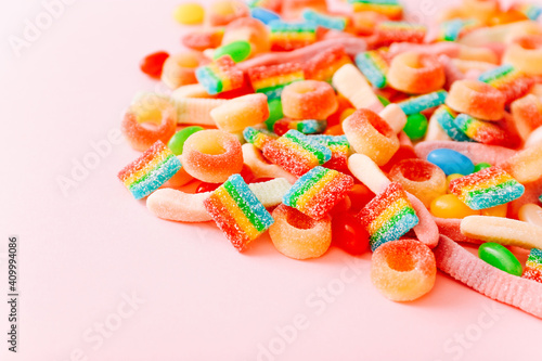 Mixed collection of colorful candy, on pink background. Close up