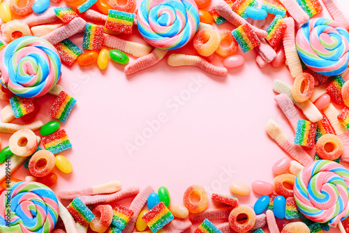 Frame from mixed collection of colorful candy, on pink background. Flat lay, top view