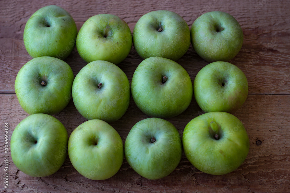 Green apples stand on a wooden surface Green apples stand on a wooden surface