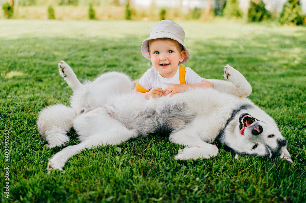 A funny little boy posing with the dog in the garden A funny little boy posing with the dog in the garden