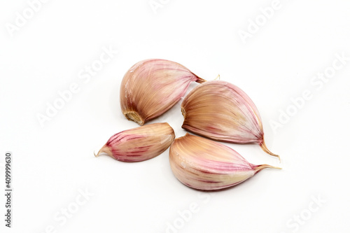 Close up of cloves of fresh garlic or "Allium sativum" on a plain white background. No people. Copy space.