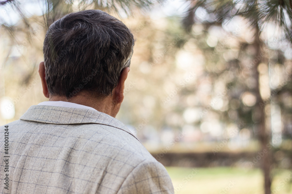 Senior man walking, hands clasped. Senior man walking and relaxing in park. Walking away, relaxing, rear view Senior man walking, hands clasped. Senior man walking and relaxing in park. Walking away, relaxing, rear view