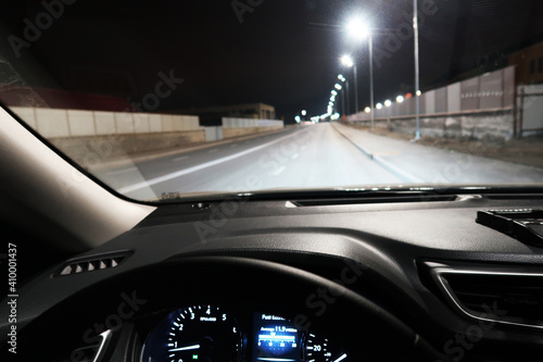 Car interior and a night road with cars and lampposts