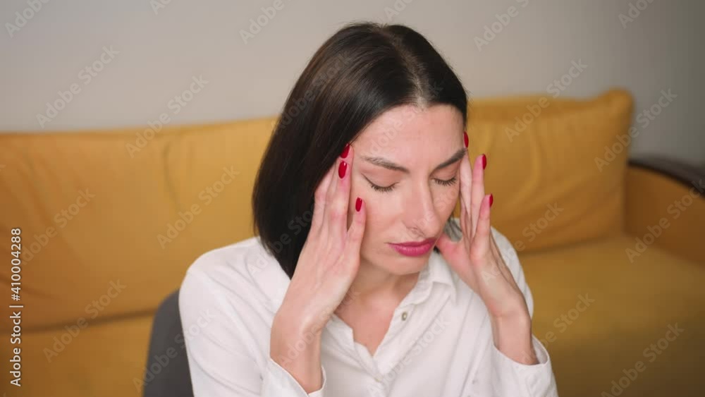 Portrait of exhausted frustrated woman massaging nose bridge temples. Stressed unhealthy woman feeling tired suffering from migraine, panic attack, high blood pressure. Portrait of exhausted frustrated woman massaging nose bridge temples. Stressed unhealthy woman feeling tired suffering from migraine, panic attack, high blood pressure.