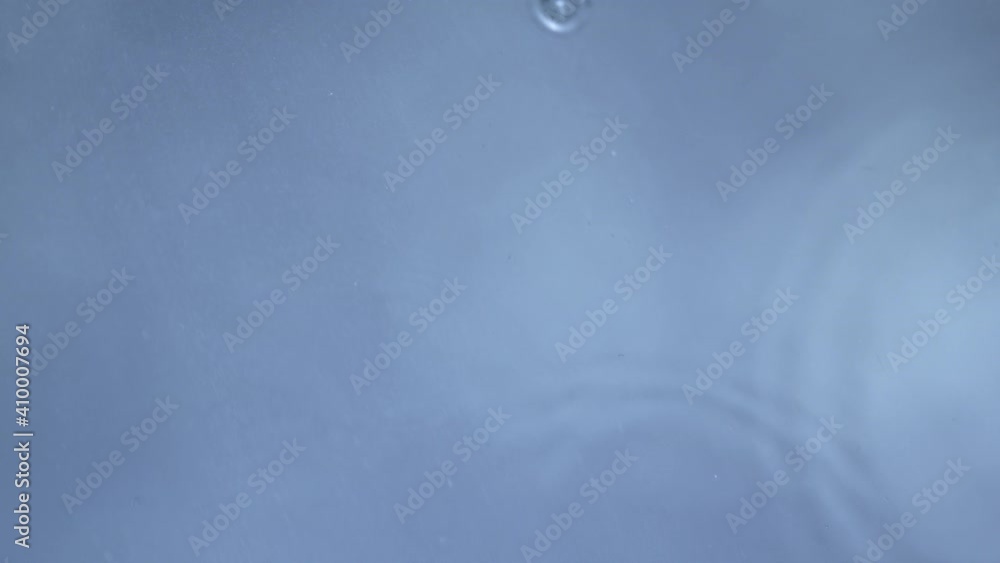 Super Slow Motion Top Shot of Water Drops Falling into Water Surface at 1000fps. Super Slow Motion Top Shot of Water Drops Falling into Water Surface at 1000fps.