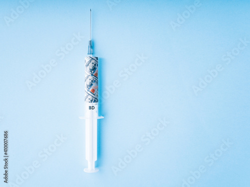 dollar injection: a syringe with a banknote inside for a recovery economy. Vaccine price or vaccine cost concept. Covid vaccine cost symbol. Pharmacy business concept.