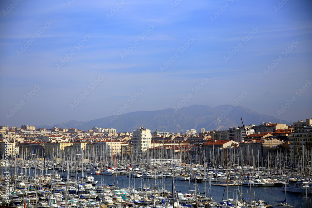 Top view of the Vieux Port of Marseille, with the mountains in the background  