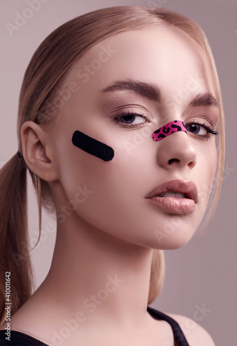Beautiful blonde girl with glamour plasters on her face