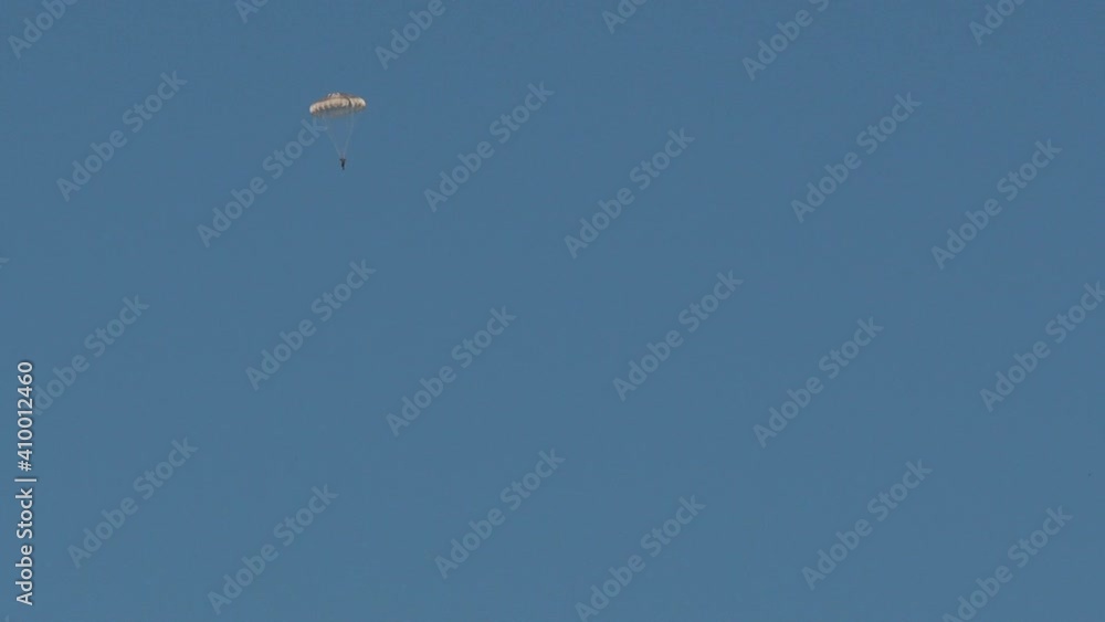A paratrooper in the sky with a parachute.
A person falling from the sky by parachute. A paratrooper in the sky with a parachute.
A person falling from the sky by parachute.