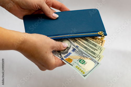 Woman getting money out of her blue wallet