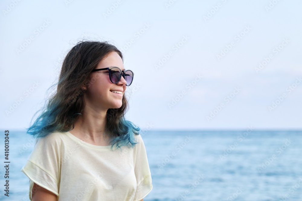 Beautiful teenager girl in sunglasses on sea beach, nature sea sky background for copy space Beautiful teenager girl in sunglasses on sea beach, nature sea sky background for copy space