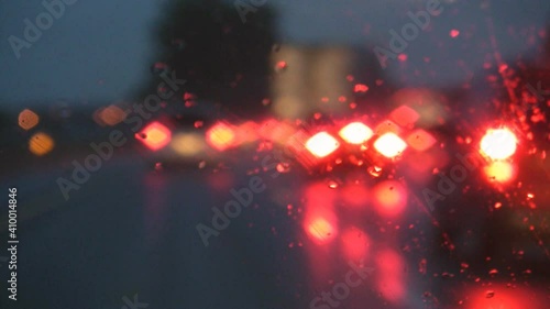 Car braking on a busy and rainy highway. Defocused lights. Rain on the windshield. Looks like an accident about to happen. Auto and Car insurance theme.
