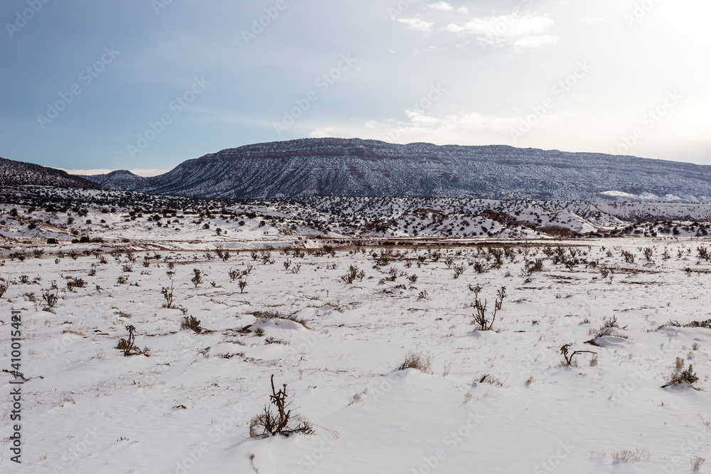 Wide open snow covered field with mountain range in distance on clear day in rural New Mexico Wide open snow covered field with mountain range in distance on clear day in rural New Mexico