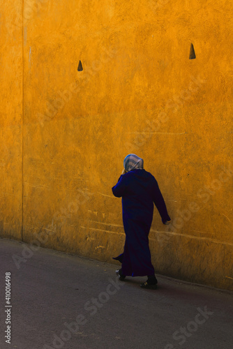 Arab woman in hijab walking alone on street photo