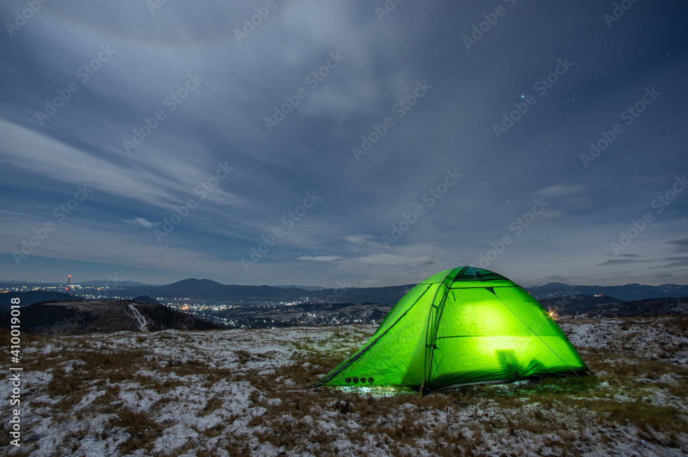 Tent in winter on top of the mountain at night