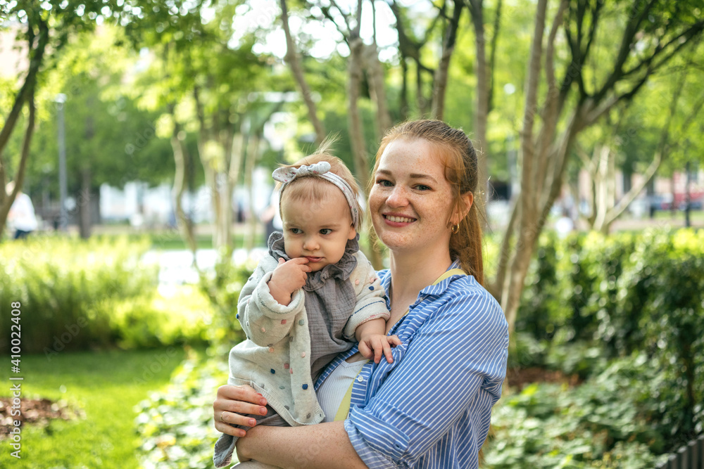 A young mother walks with a one-year-old baby. What to do while walking with your child A young mother walks with a one-year-old baby. What to do while walking with your child