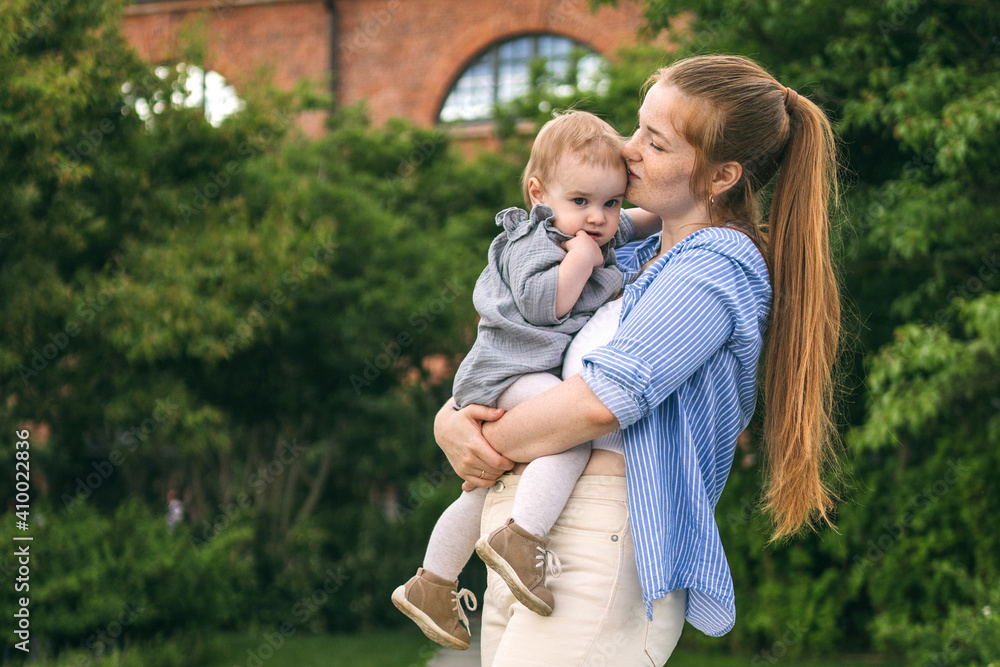 A young mother walks with a one-year-old baby. What to do while walking with your child A young mother walks with a one-year-old baby. What to do while walking with your child