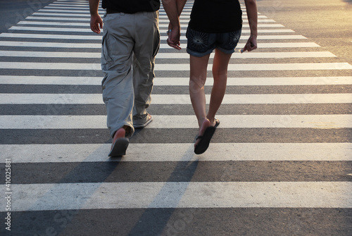 Affectionate lovers holding hands while crossing a street in Manila, Philippines