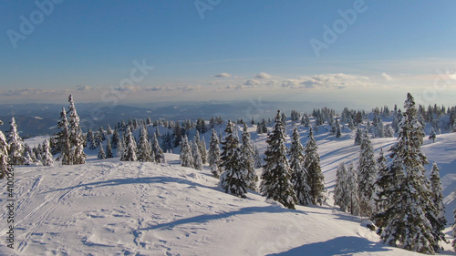 AERIAL: Idyllic view of the snow covered mountain landscape on a sunny day.