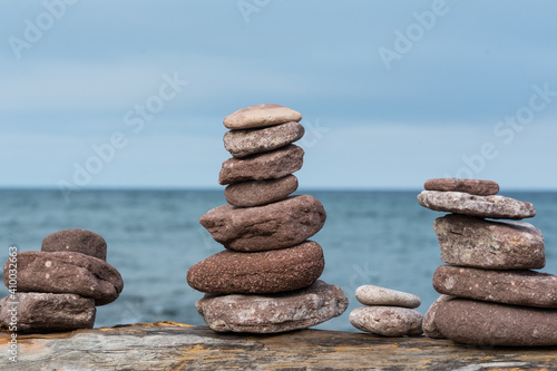 Handmade stack of stones on a piece of driftwood in front of Lake Michigan beach