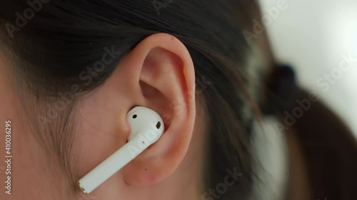 Asian woman of happy smiling are listening to music from white headphones on vacation in the house.	