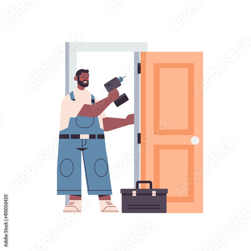 professional african american handyman in uniform installing door with electric hand drill repair service renovation concept full length isolated vector illustration