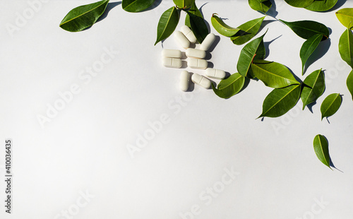  Border corner made of white pills and fresh green leaves. Template for the text of the announcement of the note. Health and nutritional theme. Minerals and vitamins.