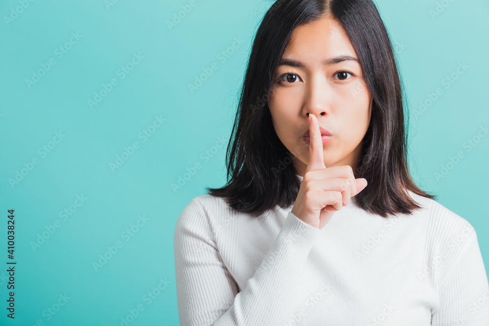 woman holding index finger on her mouth lips woman holding index finger on her mouth lips