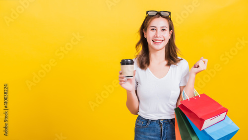 woman smiling hold shopping bags multi-color and take away coffee cup