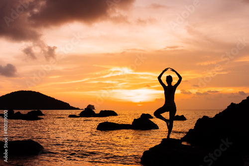 Silhouette of woman against summer sunset on sea