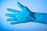 Hand wearing blue gloves for prevention on blue backrgound