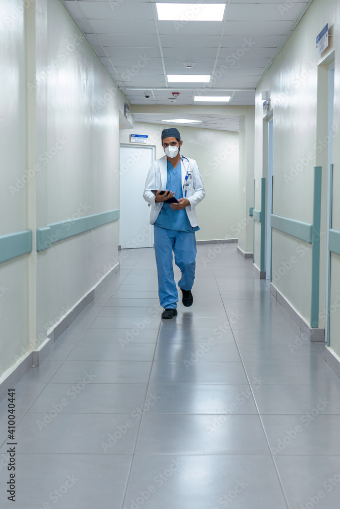 Doctor walking in the hospital with a tablet in his hands Doctor walking in the hospital with a tablet in his hands