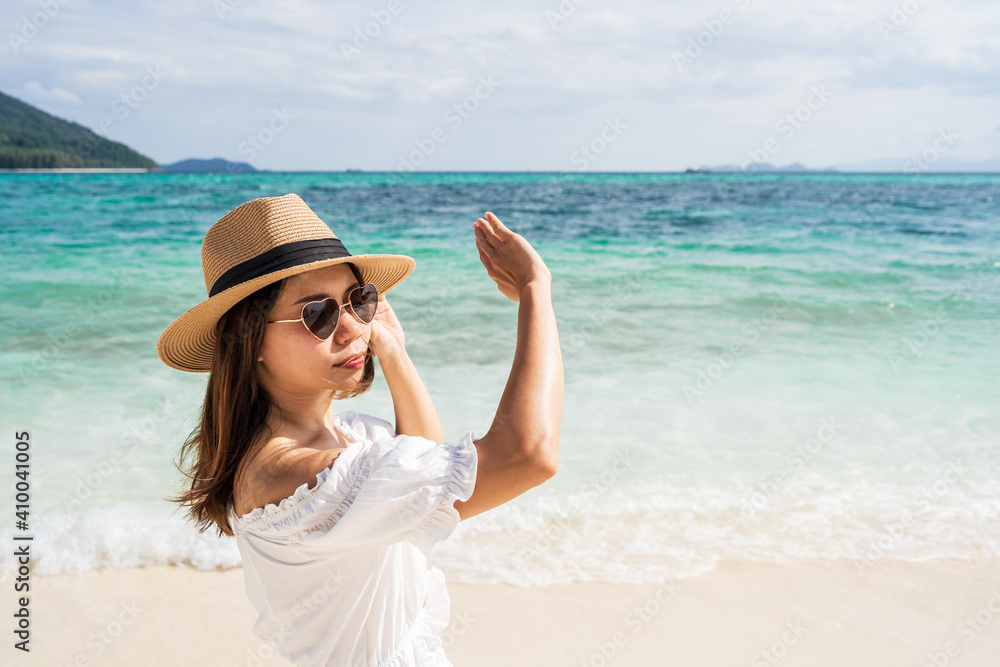 Young woman traveler wearing sunglasses covering face by hand to protect UV rays from the sun at tropical sandy beach on sunny day, Skin care and eyes protect concept Young woman traveler wearing sunglasses covering face by hand to protect UV rays from the sun at tropical sandy beach on sunny day, Skin care and eyes protect concept
