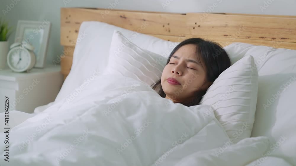 Beautiful Asian woman waking up in the morning in bed feeling happy. Beautiful Asian woman waking up in the morning in bed feeling happy.